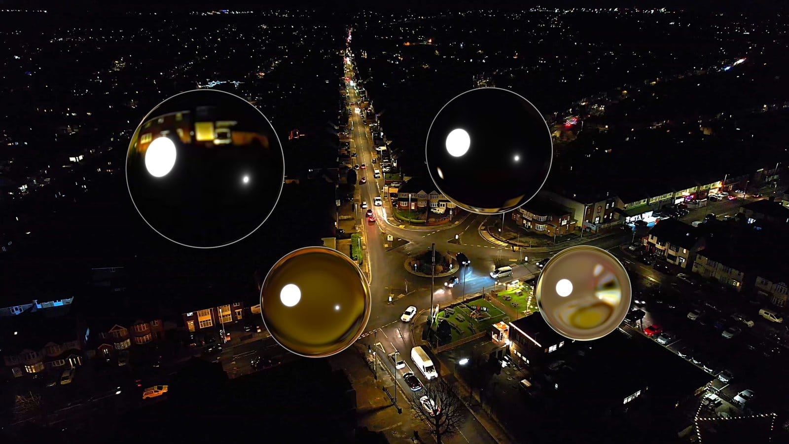 Four glass spheres with different materials over a night city